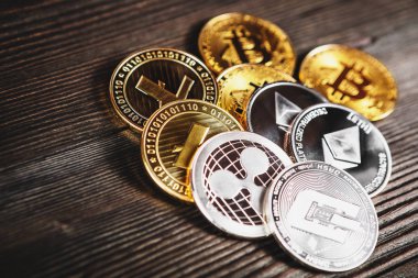 Gümüş ve altın sikkeler bitcoin, ripple ve ethereum sembolü ile