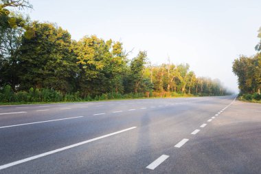 Asfalt yollar ve mavi gökyüzünün altındaki dağlar