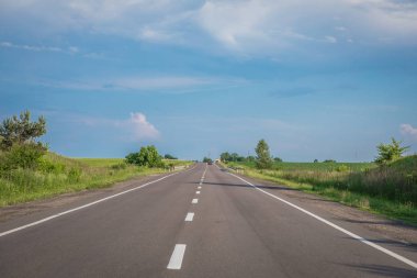 Asfalt yollar ve mavi gökyüzünün altındaki dağlar