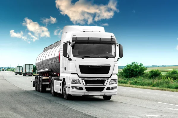 Gün batımında kırsal bir arazide beyaz bir kamyon geliyor.