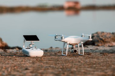 Deniz günbatımının arka planında uçan dron