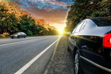 Siyah araba asfalt yolda.