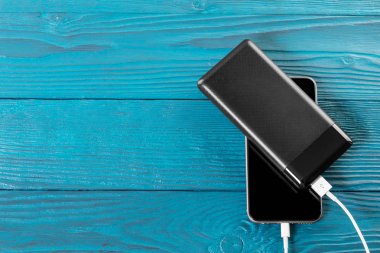powerbank ücretleri akıllı telefon ahşap arka plan üzerinde izole