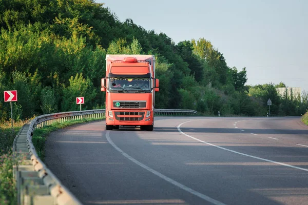 Aankomst witte vrachtwagen op de weg in een landelijk landschap bij zonsondergang — Stockfoto