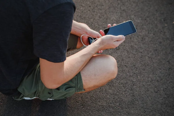 Мужские руки держат черный смартфон зарядки аккумулятор от внешней — стоковое фото