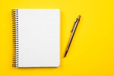 Beyaz açık not defteri sarı arkaplanda izole edilmiş.