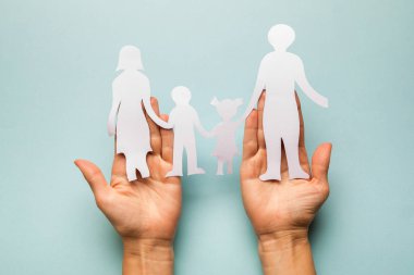 Eldeki kağıt ailesi mavi arkaplanda izole edilmiş