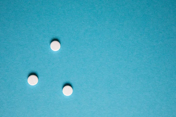 Medicamento farmacéutico comprimidos blancos sobre fondo azul. Copia s — Foto de Stock