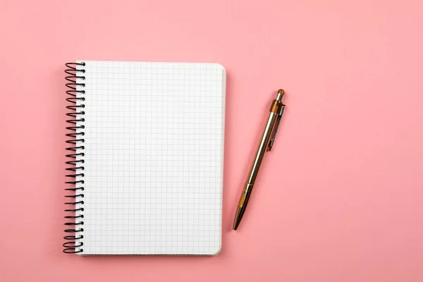 the white open notepad isolated on the pink background