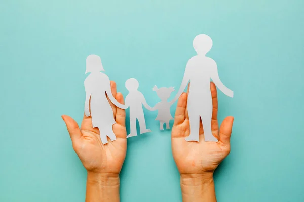 Familia de papel en mano aislada sobre fondo azul — Foto de Stock