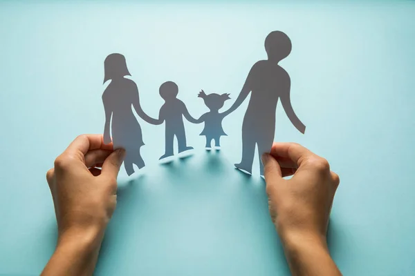 Familia de papel en mano aislada sobre fondo azul — Foto de Stock