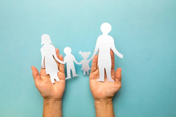 Familia de papel en mano aislada sobre fondo azul — Foto de Stock