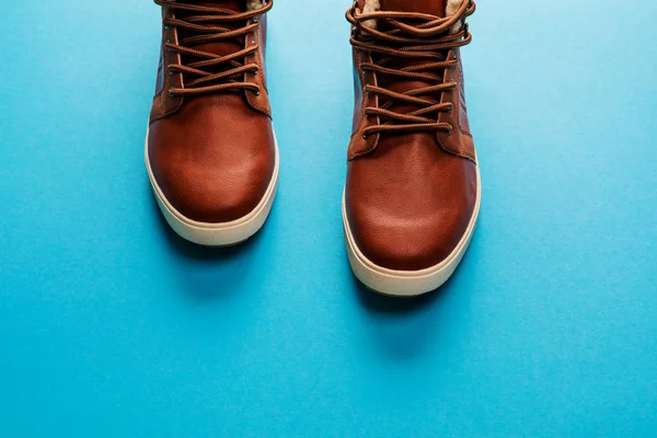 Zapatos de invierno marrones de los hombres aislados sobre fondo azul —  Fotos de Stock