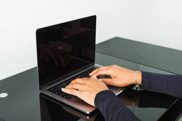 African American woman typing on a keyboard at a modern laptop