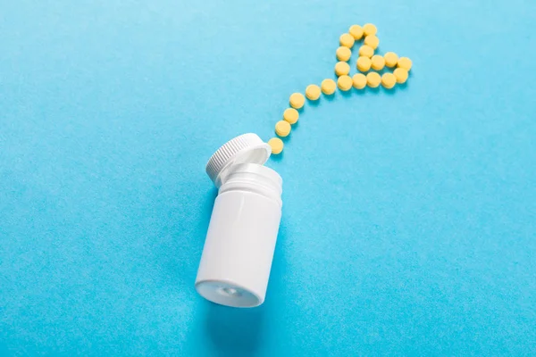 Pílulas de medicina farmacêutica, comprimidos e garrafa em azul backgr — Fotografia de Stock