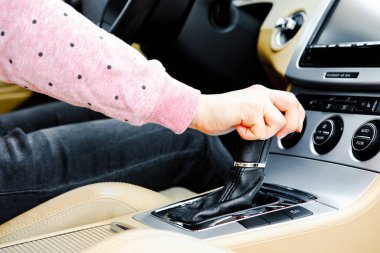 Kadın sürücü vitesi değiştiriyor.