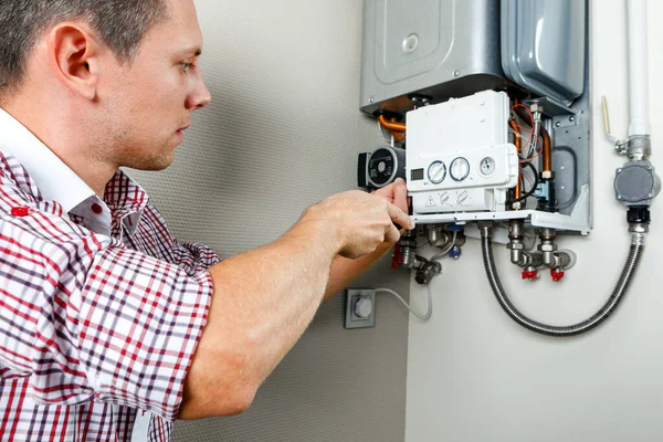 Tesisatçı, Isıtma Cihazları sorununu çözmeye çalışıyor. Gaz kazanının tamiri