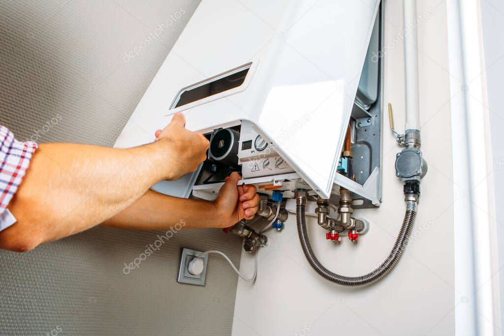 Plumber attaches Trying To Fix the Problem with the Residential Heating Equipment. Repair of a gas boiler