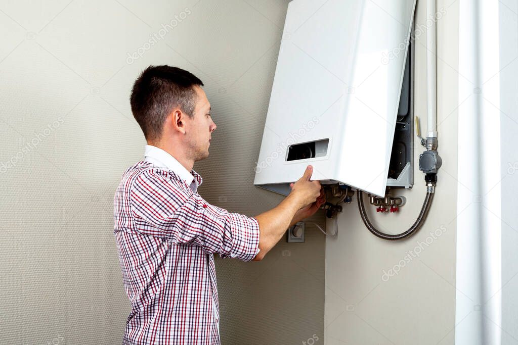 Plumber attaches Trying To Fix the Problem with the Residential Heating Equipment. Repair of a gas boiler