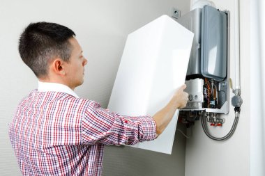 Tesisatçı, Isıtma Cihazları sorununu çözmeye çalışıyor. Gaz kazanının tamiri