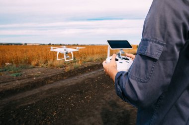 Sarı alanda dron uçuran bir adam. 
