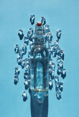 Mavi arka planda buzlu bir şişe su.