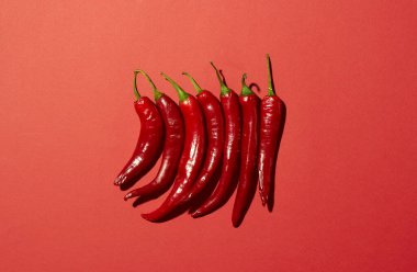 Kırmızı arka planda bir sürü kırmızı biber