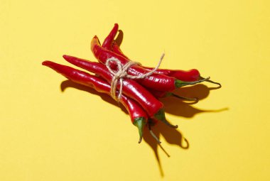 Sarı arka planda ipli kırmızı biberler