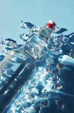 Mavi arka planda buzlu bir şişe su.