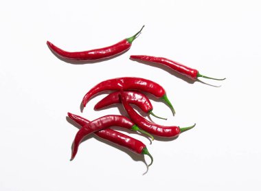 Beyaz arkaplanda birçok kırmızı biber izole edilmiş.