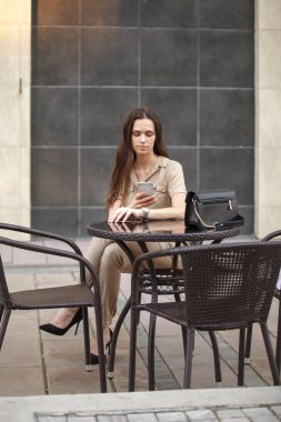 Mutlu güzel kız dışarıda akıllı telefon kullanıyor.