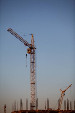 Siluetleri akşam gökyüzü kule vinç. Ev yapım aşamasında.
