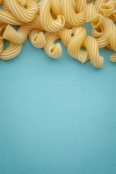 青の背景にパスタ ペンネリガーテ 調理用原料 — ストック写真