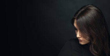 Karanlık arka planda güzel bir kızın dramatik portresi.