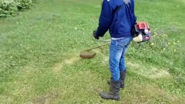 adam motor-düzeltici (çim biçme makinesi) ile çim keser. POV.