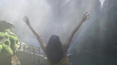 Genç kadın dinlenmek ve silah şelale için açın.