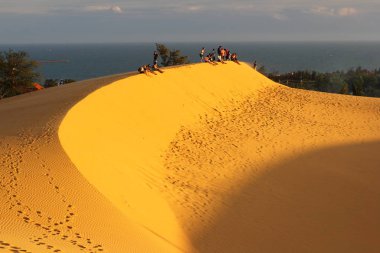 Binh Thuan, Vietnam - 06 Aralık 2018: Kırmızı kum tepeleri MUI Kuzey Vietnam. Kimliği belirsiz turist yürüyüş ve kumul zevk, turistler hayran bir günbatımı üzerinde kırmızı tepeleri. 