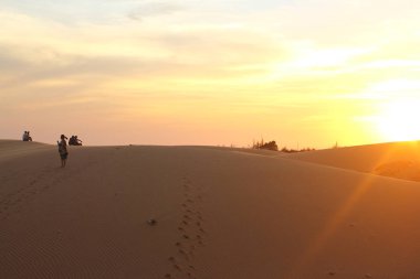 Binh Thuan, Vietnam - 06 Aralık 2018: Kırmızı kum tepeleri MUI Kuzey Vietnam. Kimliği belirsiz turist yürüyüş ve kumul zevk, turistler hayran bir günbatımı üzerinde kırmızı tepeleri. 