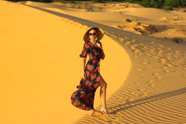 Asyalı kadın yürüyüş ve kumul keyfini çıkarın.  