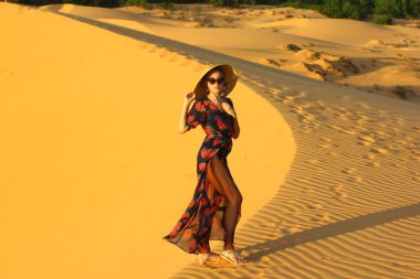 Asyalı kadın yürüyüş ve kumul keyfini çıkarın.  