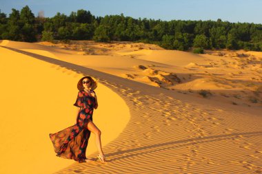 Asyalı kadın yürüyüş ve kumul keyfini çıkarın.  