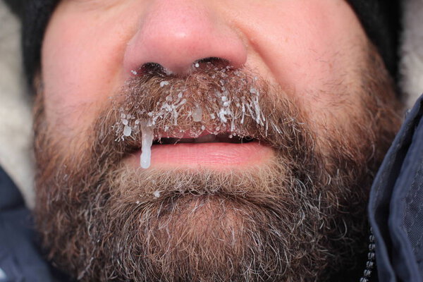 Frozen man face close-up. Frozen beard. Winter concept.
