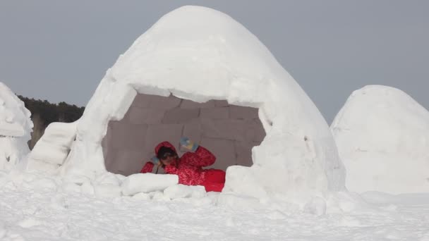 若い女性は雪の中でリラックスするイグルー 冬休み 冬とお正月のコンセプト — ストック動画