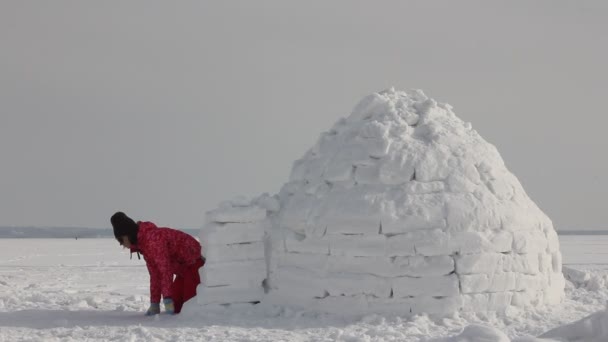 若い女性は雪の中でリラックスするイグルー 冬休み 冬とお正月のコンセプト — ストック動画