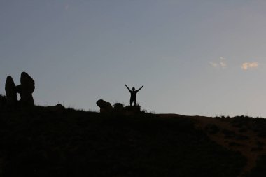 Güneş ışınları, güzellik bulutları ve siluetler ile dramatik gün batımı.