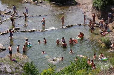 Belovo Şelalesi, Novosibirsk Region, Rusya - 13 Temmuz 2019: Şelalelerin yakınındaki sıcak yaz tatilinde insanlar rahatlayıp banyo yapıyor.