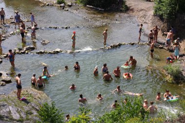 Belovo Şelalesi, Novosibirsk Region, Rusya - 13 Temmuz 2019: Şelalelerin yakınındaki sıcak yaz tatilinde insanlar rahatlayıp banyo yapıyor.