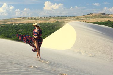 Vietnam şapkalı, beyaz kum tepelerinde uzun elbiseli güzel Vietnamlı kadın..