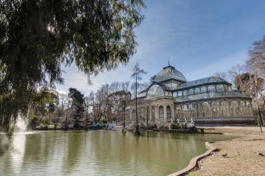 The Crystal Palace (Palacio de Cristal), a glass and metal structure built by Ricardo Velazquez Bosco in 1887 to exhibit flora and fauna from the Philippines on Buen Retiro Park in Madrid, Spain. clipart