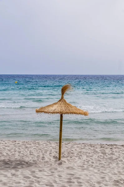 Stro paraplu op zand strand. — Stockfoto